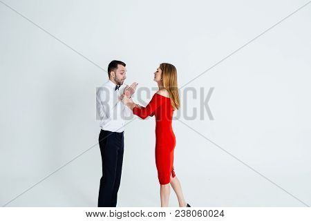 Close Up Colour Studio Portrait Of Stylish Young Couple, Pretty Woman In Red Dress Arguing With Man,