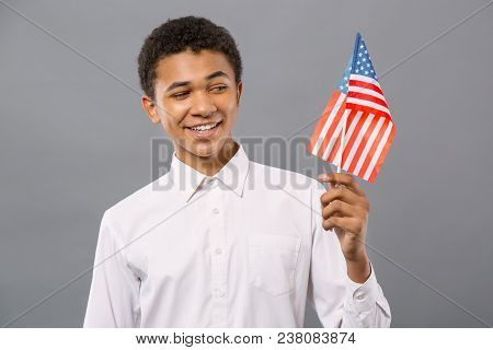 Us Citizen. Joyful Patriotic Man Smiling While Looking At The Us Flag