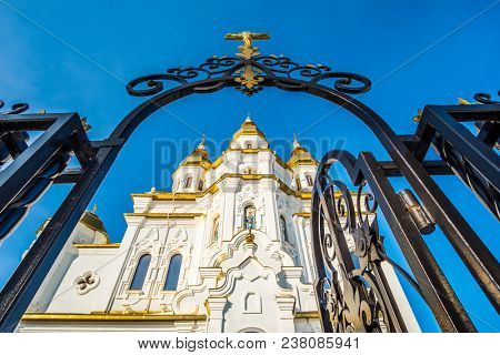 Kharkiv, Ukraine - 13 March 2018: Mironosickaya church through the gate under blue sky in Kharkiv