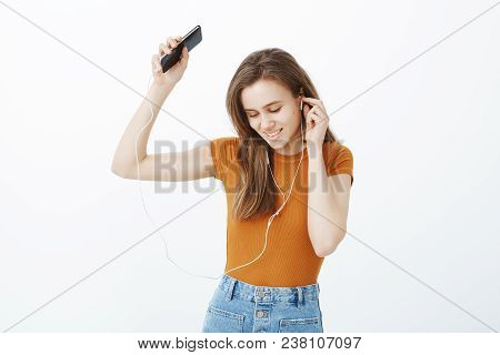 Boosting Happy Mood With Favorite Songs. Relaxed Charming European Female Student In Colorful Clothe