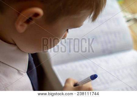 Home Education. Boy Hand With Pen Writing English Words By Hand On Traditional White Notepad Paper. 