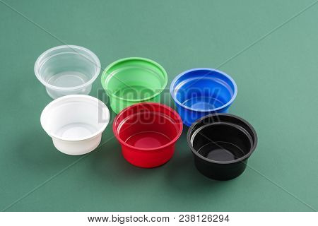 Folded Plastic Containers For Eating Different Colors On A Green Background