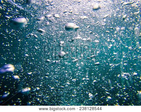 Air boobles in blue sea water. Maldives.