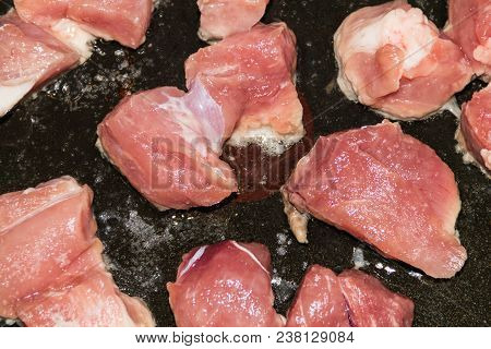 The Sliced Meat Is Fried In A Black Pan, The Red Meat Is Fried In Oil, Cooking The Meat