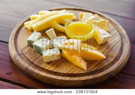 Cheese Plate. Assortment Of Various Types Of Cheese On Wooden Cutting Board.