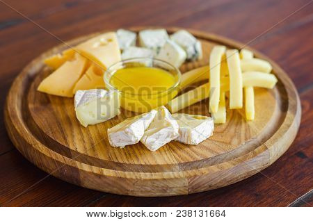 Cheese Plate. Assortment Of Various Types Of Cheese On Wooden Cutting Board.