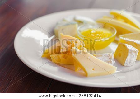 Cheese Plate. Assortment Of Various Types Of Cheese On Wooden Cutting Board.