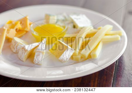 Cheese Plate. Assortment Of Various Types Of Cheese On Wooden Cutting Board.