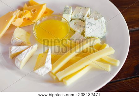 Cheese Plate. Assortment Of Various Types Of Cheese On Wooden Cutting Board.