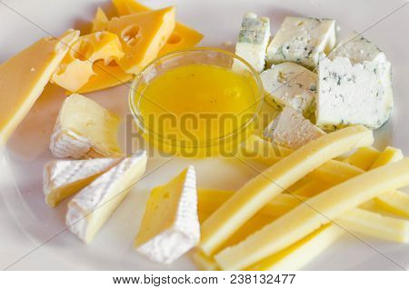 Cheese Plate. Assortment Of Various Types Of Cheese On Wooden Cutting Board.