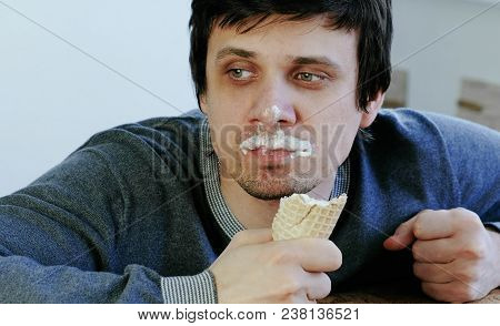 Closeup Of Young Lousy Man Eats Ice Cream