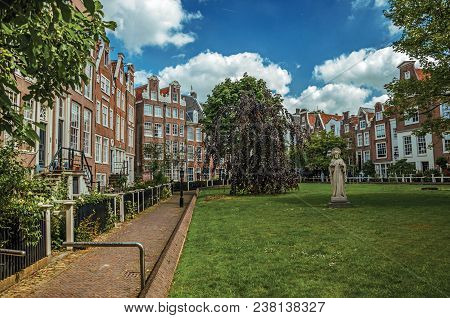 Amsterdam, Northern Netherlands - June 26, 2017. Semidetached Typical Houses And Green Garden At Beg