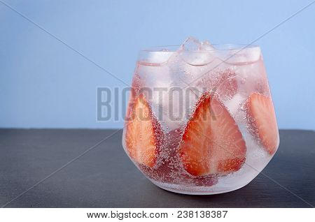 Strawberries In Sparkling Water On The Blue Background. Glass Of Strawberry Summer Water. Cold Fruit