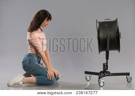 Young Brunette Woman With Raised By The Wind Machine. Studio Shot Over Gray Background