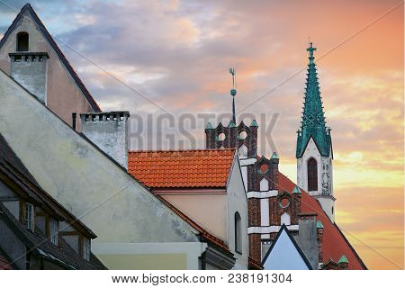 Red Roofs Of Old Houses In Skarnu Iela Street With St Johns Church In The Background Riga Latvia.