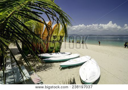 Colorful Stacking Kayaks On White Sandy Beach At Sunny Day. Blue Sky And Clear Sea Water Background.