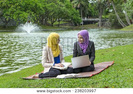 Portrait Of Young Lovely Pleasant Mix Ethnic Woman Sitting On Grass At Summer Green Park And Having 