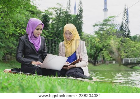 Portrait Of Young Lovely Pleasant Mix Ethnic Woman Sitting On Grass At Summer Green Park And Having 