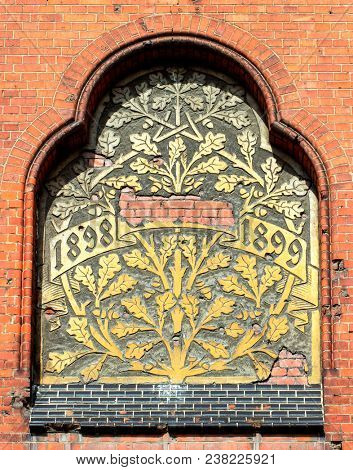 Ancient bass relief showing a big tree on brick wall from 1899