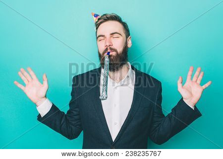 Happy Man Is Standing And Enjoying The Moment. He Has A Birthday Hat On His Head And Holding A Wistl