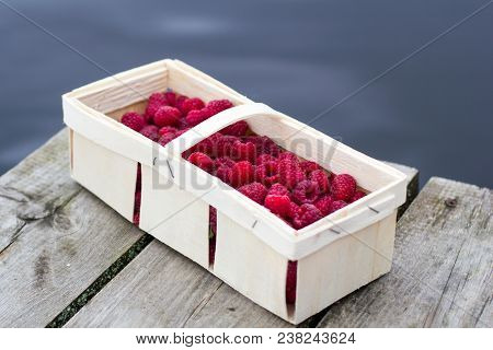 A Small Picnic With A Small Craft Box Of Fresh Organic Raspberries On The Pier At The Lake In The Su