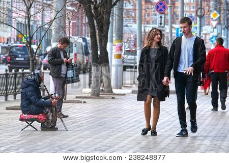 Tula, Russia - April, 28, 2018: pedestrians pass by beggar on Tula street