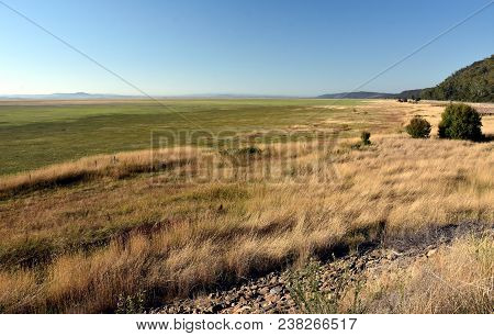 Empty Lake George Nestled Between A Rural Wind Farm And Farmland In Australia. Lake George Is An End