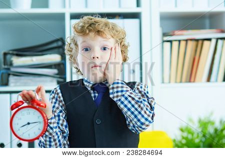 Disappointed Kid Boss Holding A Big Red Alarm Clock In His Hand Suggesting You Are Late For Work. Wo