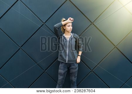 Sporty Woman With Perfect Figure And Buttocks Stretching Her Arms Against Wall With Copy Space For Y