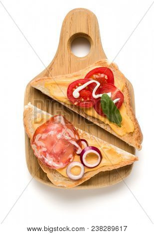 Open  faced sandwich canape or crostini on a wooden serving board  isolated on white background closeup. Top view.