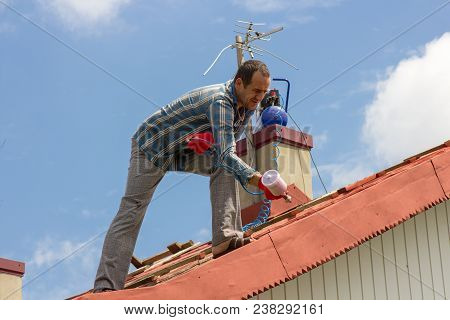 Services On Painting A Roof At The House In A Red Color
