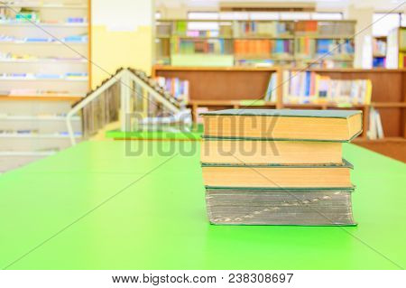 Old Book And Heap Treatise In School Library On Table Green. Blurry Bookshelves Background. Educatio