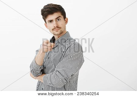 Portrait Of Confident Joyful Male Enterpreneour With Moustache, Pointing At Camera And Lifting Eyebr