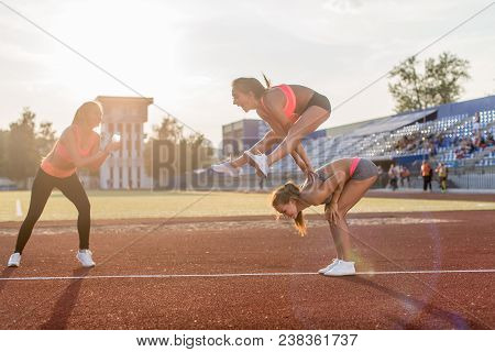 Fit Women In The Stadium Playing Leap Frog