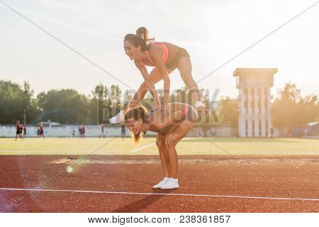 Fit Women At The Stadium Playing Leap Frog