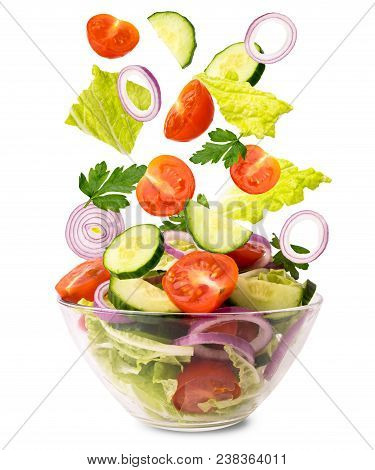 Fresh Vegetable Salad. Vegetables Falling Into A Bowl With Salad On A White Background, Isolated.