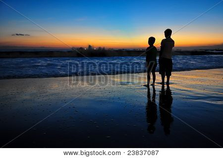 Zwei jungen am Meer bei Sonnenuntergang