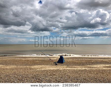 Fishing in the North Sea from the beach at Dunwich, Suffolk, UK