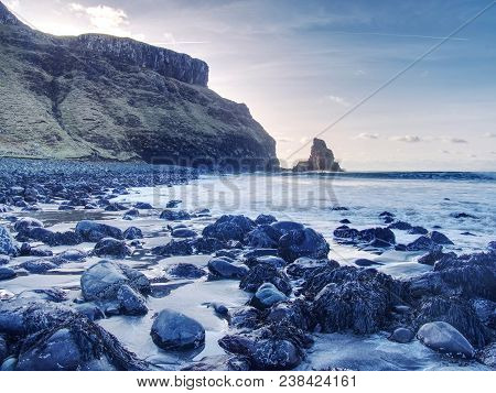 Amazing Sunset, Talisker Bay On The Isle Of Skye In Scotland. Foamy Sea, Boulders And Large Cracked 