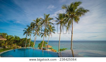 Outdoor Swimming Pool In A Tropical Country Philippines With Palm Trees. Evening Time.