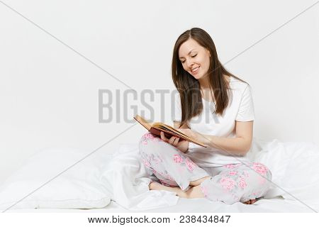 Young Happy Woman Sitting In Bed With White Sheet, Pillow, Blanket On White Background. Beauty Femal