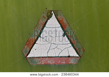 Old Faded And Chipped Slow Moving Vehicle Sign On The Back Of A Green Machine