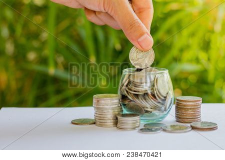 Hand Of  Female Putting Coins In Jar With Money Stack Step Growing Growth Saving Money