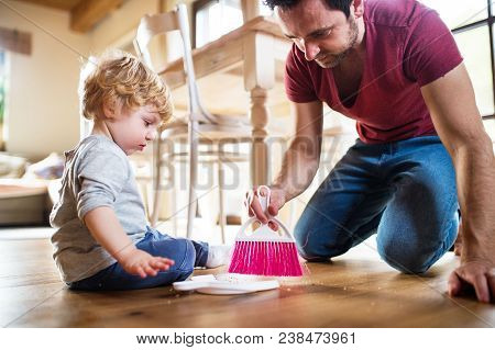 A Handsome Father And Toddler Boy With Brush And Dustpan. Paternity Leave.