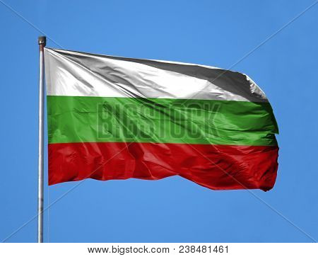National Flag Of Bulgaria On A Flagpole In Front Of Blue Sky.