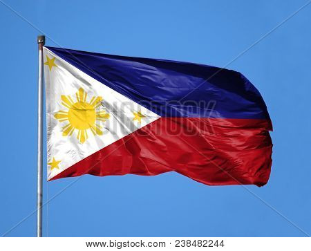 National Flag Of Philippines On A Flagpole In Front Of Blue Sky.