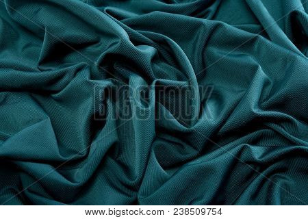 Smooth Green Satin Silk Fabric. Folds, Curl. Satin Background.