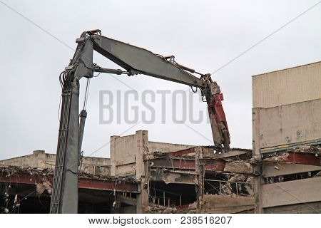 A Pulveriser Machine Pulling Out A Building Steel Girder.