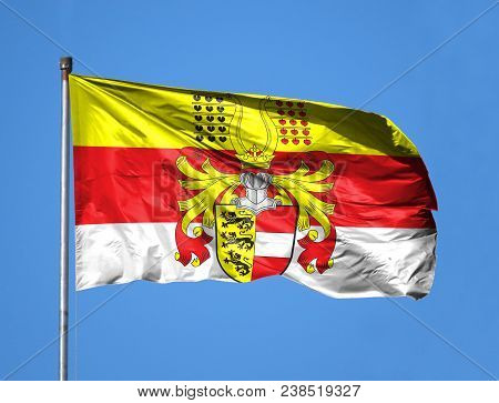 National Flag Of Carinthia On A Flagpole In Front Of Blue Sky.