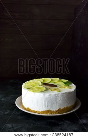 Sweet White Buttercream Round Cake With Sliced Lime Against A Dark Background